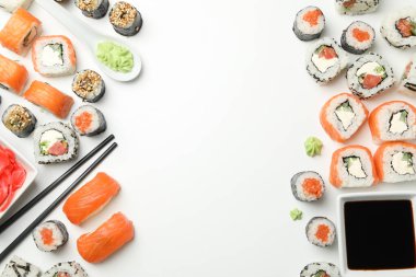 Suşi ruloları ve yemek çubukları beyaz arka planda, mesaj için yer var. Japon yemeği.
