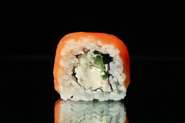 Suşi siyah ayna arkaplanında yuvarlanıyor, kapat