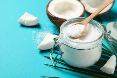 Hindistan cevizi, palmiye dalı ve turkuaz arka planda kozmetik. Tropik meyve