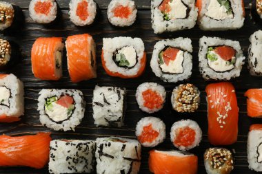Ahşap zemin üzerinde suşi ruloları ile düz yatıyordu. Japon yemeği.