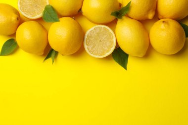 Sarı arka planda limonlar, üst manzara. Taze meyve.