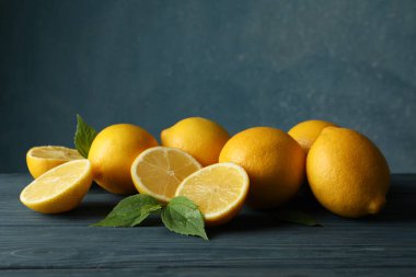 Tahta masada taze limon ve yapraklar. Olgun meyve