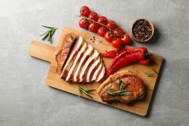 Gri arka planda kızarmış biftekli pano. Izgara yemek.