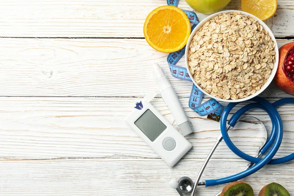 Blood glucose meter and diabetic food on wooden table