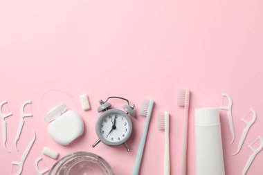 Pembe arka planda diş bakımı araçları, üst görünüm