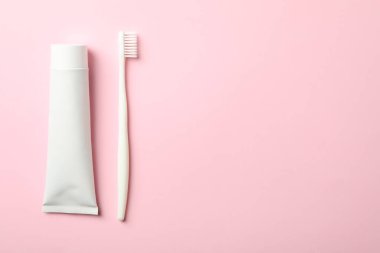 Pembe arkaplanda diş fırçası ve diş macunu, metin için boşluk