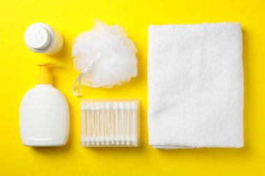 Sarı arka planda bebek hijyen aksesuarlarıyla yatıyordu.