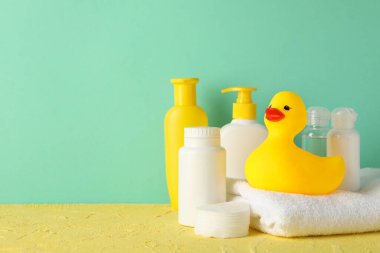 Bebek hijyeni aksesuarları nane arkaplanına karşı sarı masada.