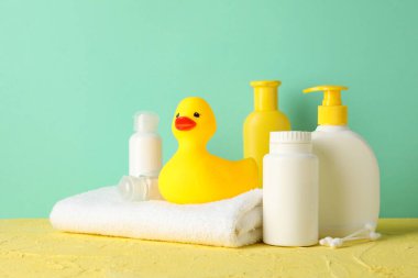 Bebek hijyeni aksesuarları nane arkaplanına karşı sarı masada.