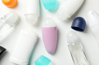 Beyaz arka planda farklı vücut deodorantı, üst görünüm