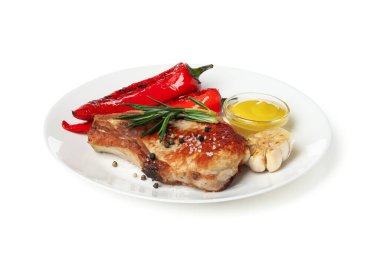 Beyaz arka planda ızgara biftek ve sebzeli tabak.