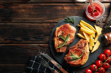 Ahşap arka planda kızarmış biftek kompozisyonu. Izgara yemek.