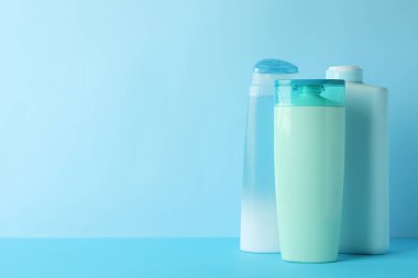 Mavi arka planda kozmetik ürünleri için boş şişeler