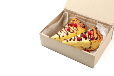 Çıkartma kutusundaki peynirli kek beyaz arkaplanda izole edildi