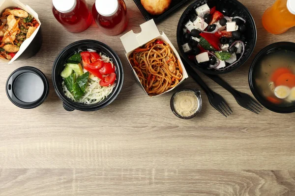 Food delivery. Food in takeaway boxes on wooden table