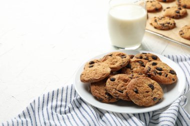 Beyaz masa üzerinde çipli kurabiye ve sütle kompozisyon