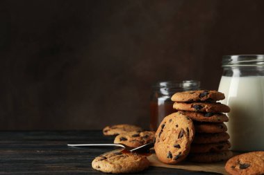 Tahta masanın üzerinde cips, süt ve karamel ile kompozisyon