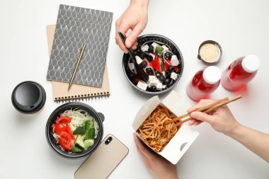 İnsanlar paket servis yiyor. Yemek servisi. Beyaz masada lezzetli yemekler.