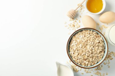 Beyaz arka planda yulaf ezmeli kompozisyon, üst manzara. Kahvaltı hazırlıyorum.