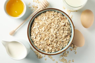 Beyaz arka planda yulaf ezmeli kompozisyon, üst manzara. Kahvaltı hazırlıyorum.