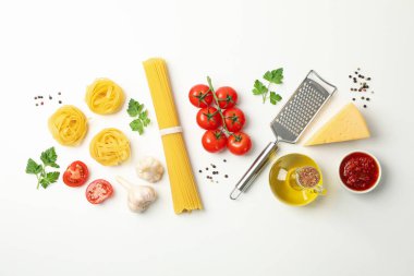 Makarna ve beyaz arka planda yemek pişirmek için malzeme içeren kompozisyon, üst görünüm