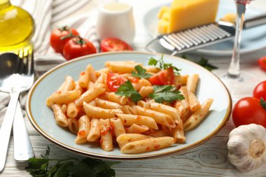 Lezzetli makarna ve ahşap arka planda yemek pişirmek için malzemeler içeren kompozisyon