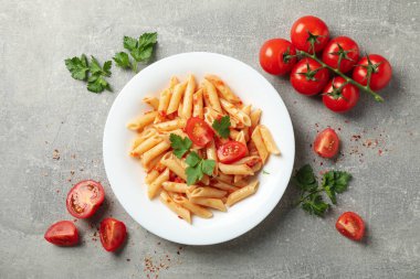 Gri zemin üzerinde lezzetli makarna tabağı olan kompozisyon, üst görünüm