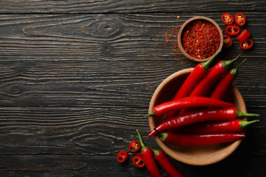 Baharat ve kase ve ahşap arka planda kırmızı biber.