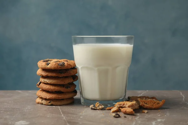 チョコレートチップクッキーと茶色のテーブルの上の牛乳のガラス — ストック写真