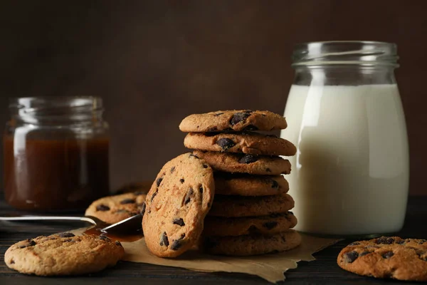 Komposition Mit Chips Milch Und Karamell Auf Holztisch — Stockfoto