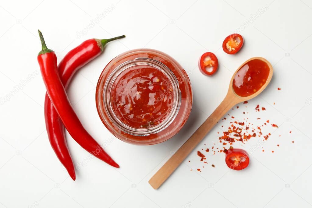 Composition with chilli pepper, spice and sauce on white background