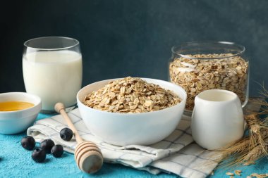 Mavi arka planda yulaf ezmesi parçaları olan kompozisyon. Kahvaltı hazırlıyorum.