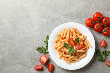 Gri zemin üzerinde lezzetli makarna tabağı olan kompozisyon, üst görünüm