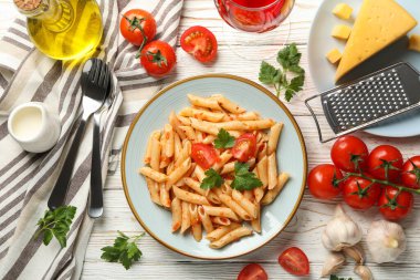 Lezzetli makarna ve ahşap arka planda yemek pişirmek için malzemeler içeren kompozisyon