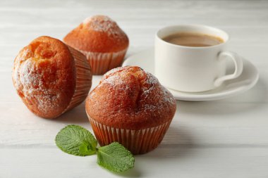 Beyaz ahşap arka planda lezzetli kekler ve kakao içecekler.