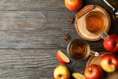 Elma şarabı, tarçın ve ahşap arka planda elmalarla kompozisyon