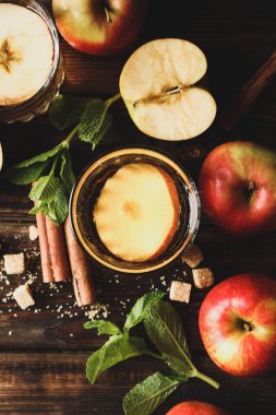 Elma şarabı, şeker, tarçın ve elmalarla ahşap masada kompozisyon