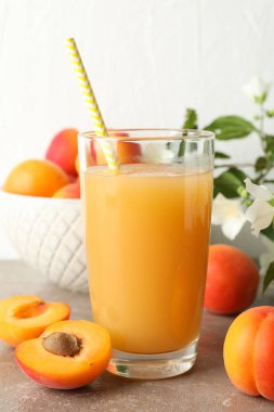 Lezzetli kayısılı kompozisyon ve gri masada meyve suyu.