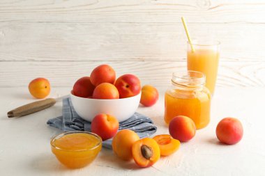 Kayısı, meyve suyu ve reçelli kompozisyon beyaz masada.