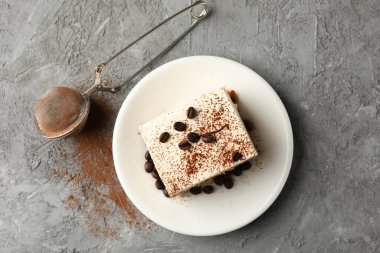 Gri arka planda lezzetli tiramisu tabağıyla kompozisyon