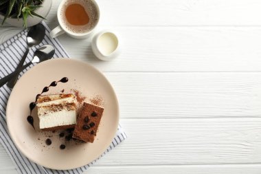 Lezzetli tiramisulu kompozisyon ve beyaz ahşap masada kakao içeceği. Tatlı nefis.