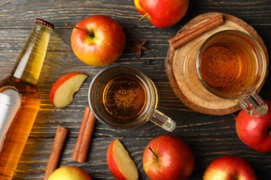 Elma şarabı, tarçın ve ahşap arka planda elmalarla kompozisyon