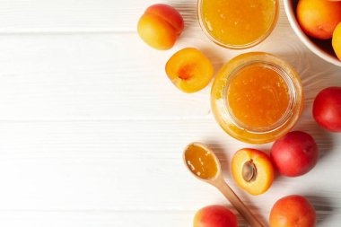 Lezzetli kayısılı kompozisyon ve beyaz ahşap masada reçel.