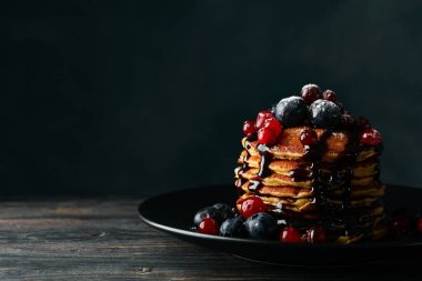 Ahşap arka planda krep ve böğürtlen tabağı. Tatlı kahvaltı.