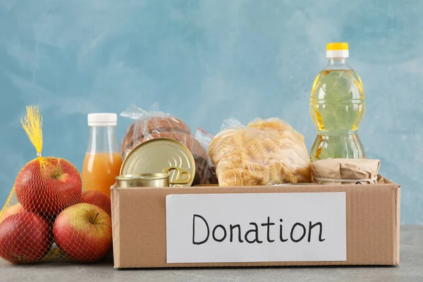 Caja Donaciones Con Diferentes Alimentos Mesa Gris Voluntariado — Foto de Stock