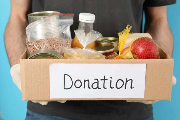 Joven Sostiene Caja Donaciones Contra Fondo Azul Voluntario — Foto de Stock
