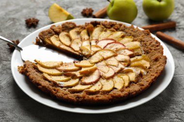 Elmalı turta ve gri arka plandaki malzemelerle kompozisyon. Ev yapımı yemek.