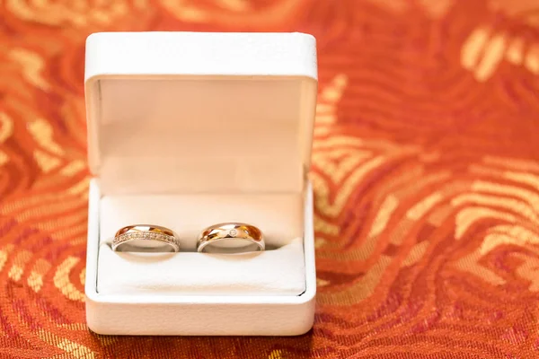 Anillos de boda de oro en almohada de satén — Foto de Stock