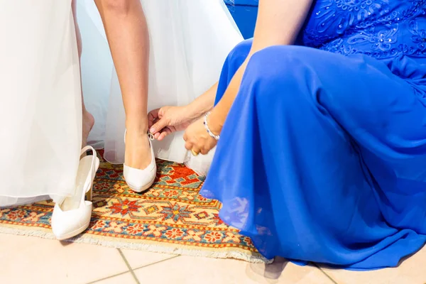 Noiva em um belo vestido de noiva colocando em sapatos — Fotografia de Stock