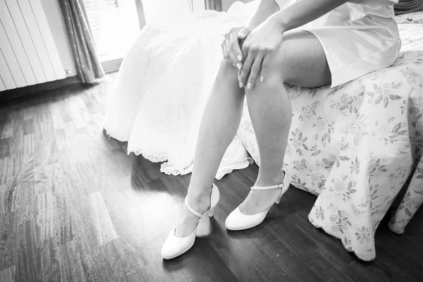 Novia en un hermoso vestido de novia poniéndose zapatos —  Fotos de Stock